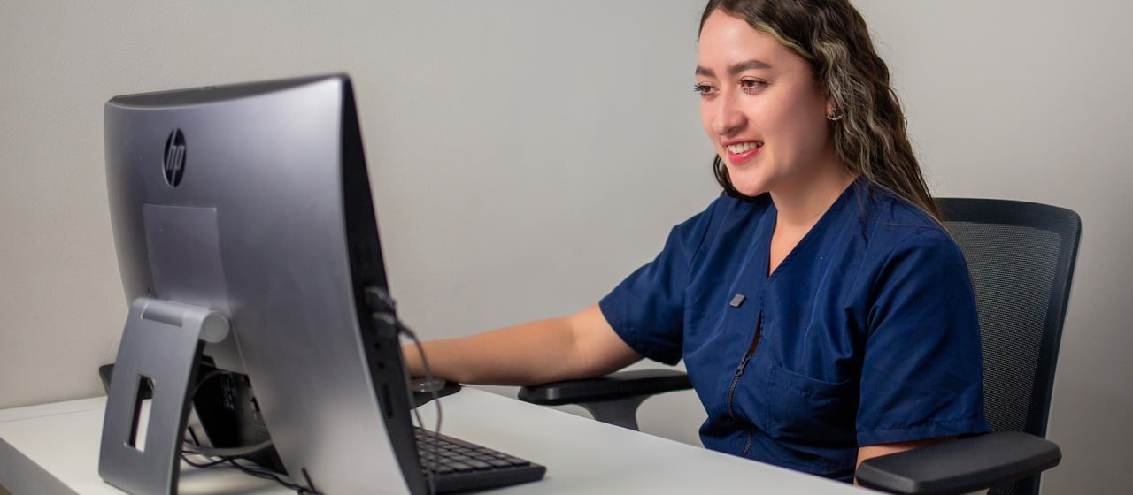 Coordinadora de una clínica respondiendo mensajes de pacientes desde su computador