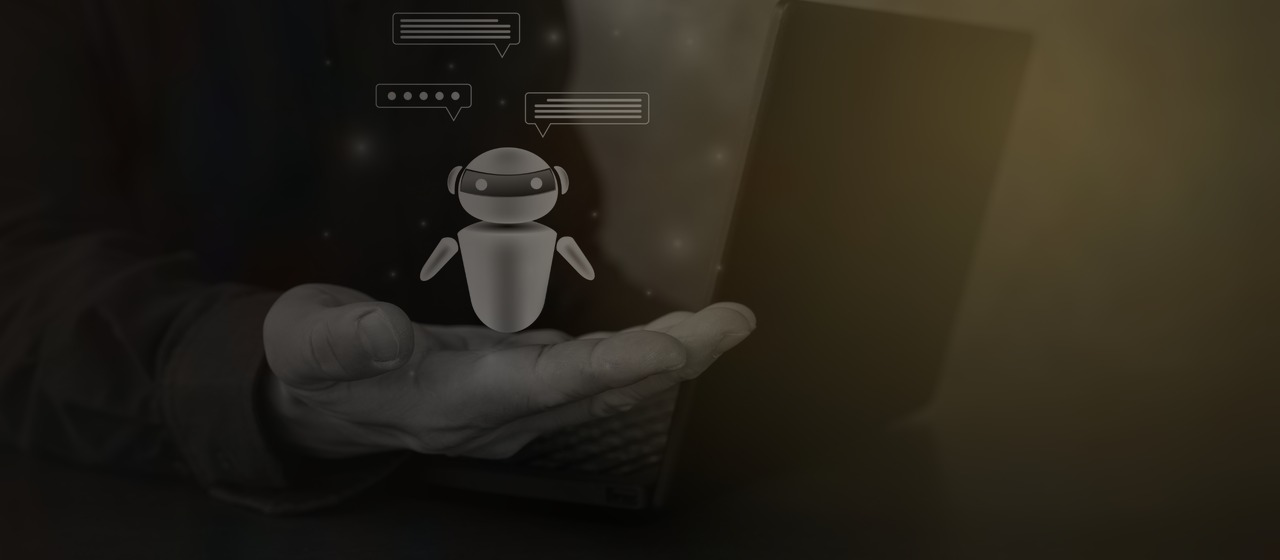Robot de chat flotando sobre la mano de una persona frente a un portátil