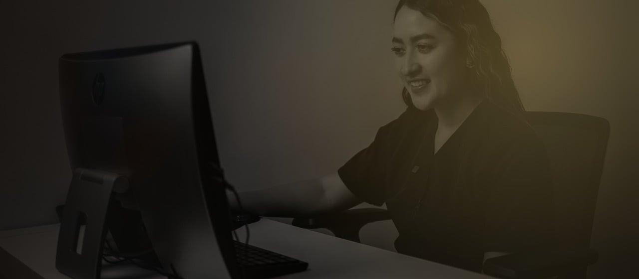 Coordinadora de una clínica respondiendo mensajes de pacientes desde su computador