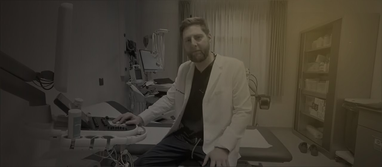 Cardiólogo en su consultorio frente al equipo de diagnóstico
