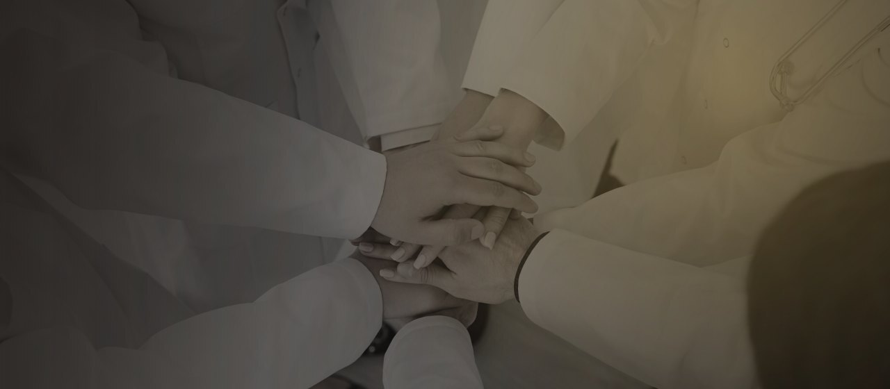 Equipo médico con las manos unidas, interoperabilidad en salud